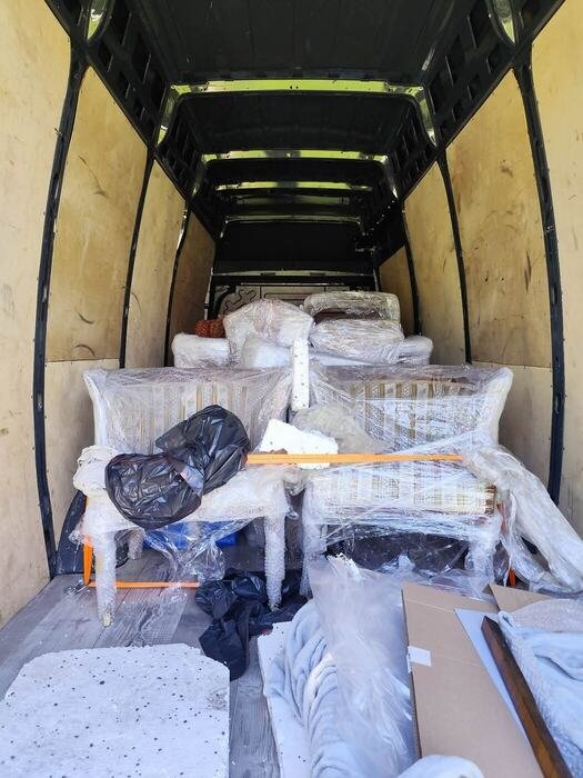 Kartony i meble ułożone na pace busa przed transportem